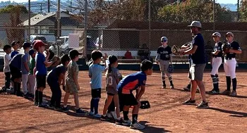 A coach leading players through a fielding drill